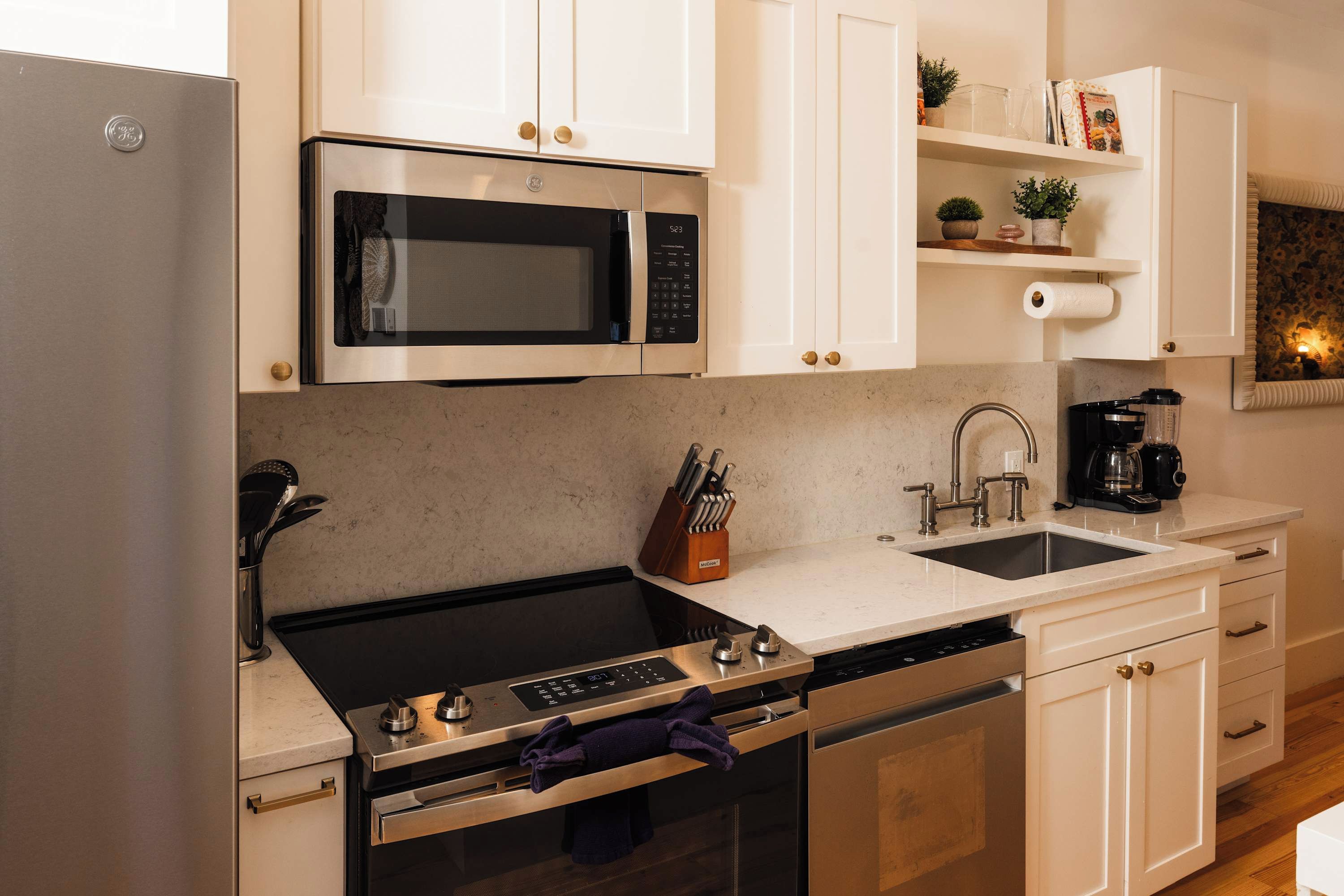 A modern kitchen with a stainless steel refrigerator, a built-in microwave, a gas stove, a dishwasher, and a sink.
