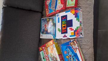A variety of board games laid out on a couch.