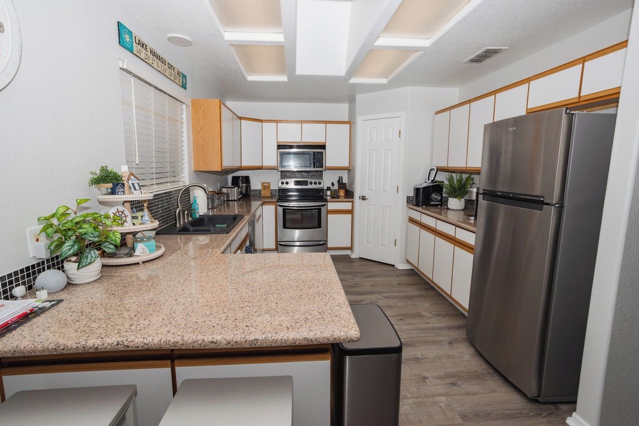 A modern kitchen with a central island, stainless steel appliances, and a view of Lake Havasu City.