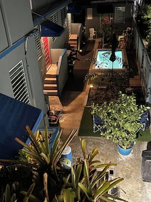 Ein Innenhof mit Schwimmbecken, Topfpflanzen und Gartenmöbeln.