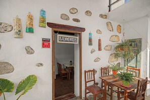A rustic interior with a wooden table and chairs, a welcome sign, and various wall decorations including stones and painted panels. - Vacation Home 'Gloria' with Mountain Views, Shared Terrace & Wi-Fi (Arucas)