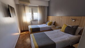 A hotel room with two beds, a wooden headboard, a bedside table with a phone, and a window with curtains. - AURA HOTEL RECOLETA (Buenos Aires)