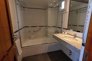 A bathroom with a bathtub, a shower, and a sink. - Aura Hotel Recoleta (Buenos Aires)