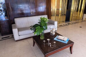 Un espace d’accueil avec un canapé, une table basse agrémentée d’objets décoratifs et un livre.