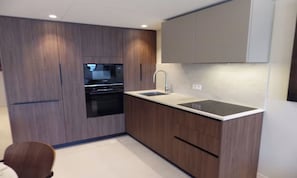 A modern kitchen with built-in appliances, a sink, and wooden cabinetry. - LUXURY BEACHFRONT APARTMENT WITH CROISETTE & SEA VIEWS (Cannes)