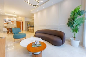 Ein modernes Wohnzimmer mit einer Couch, einem Couchtisch und einer Zimmerpflanze.