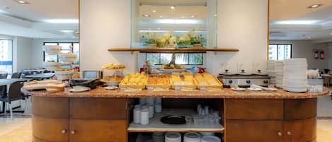 Mesa de buffet con diferentes alimentos, un espejo y un extintor.