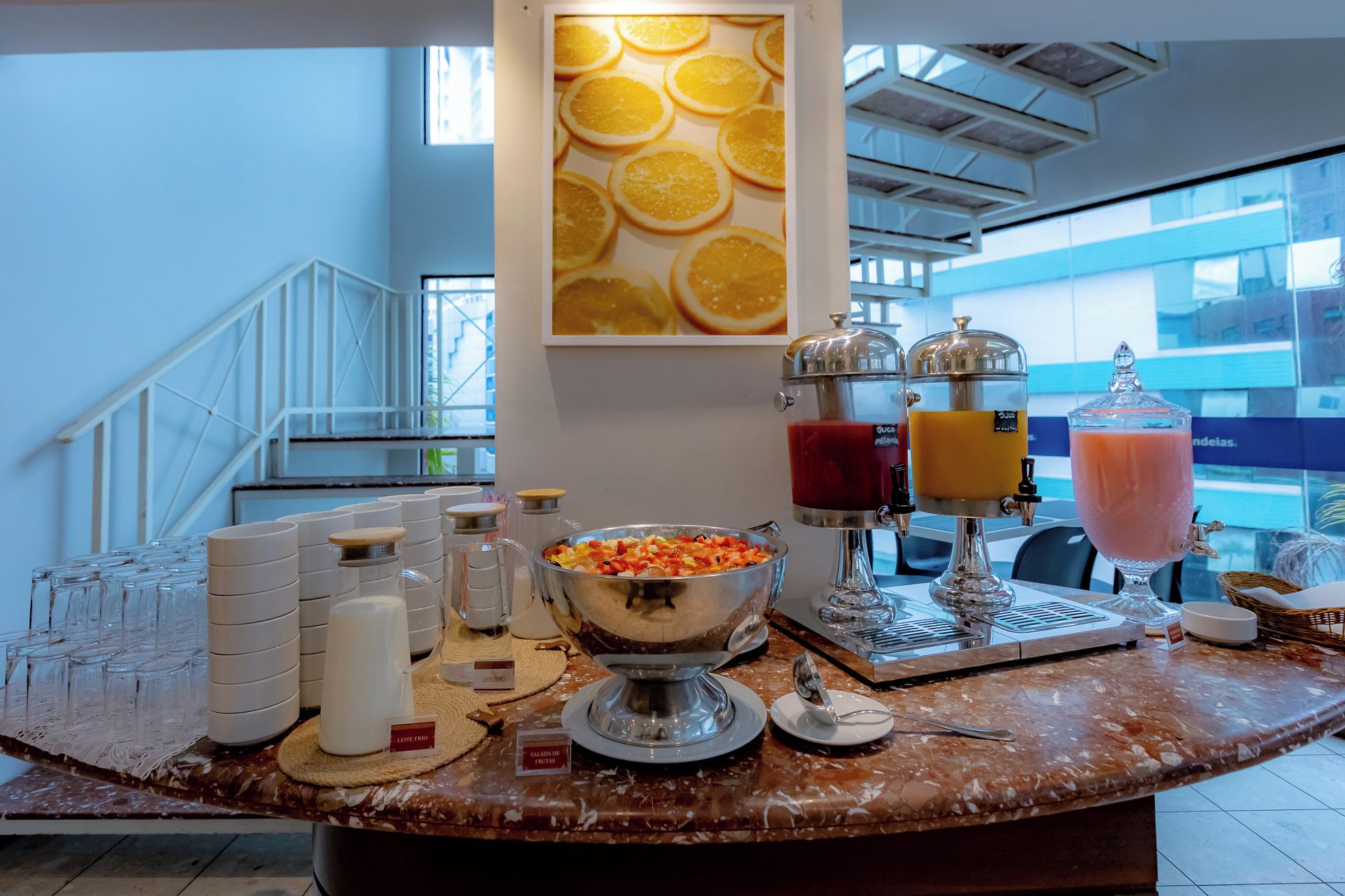 A breakfast buffet with various food items and drink dispensers.