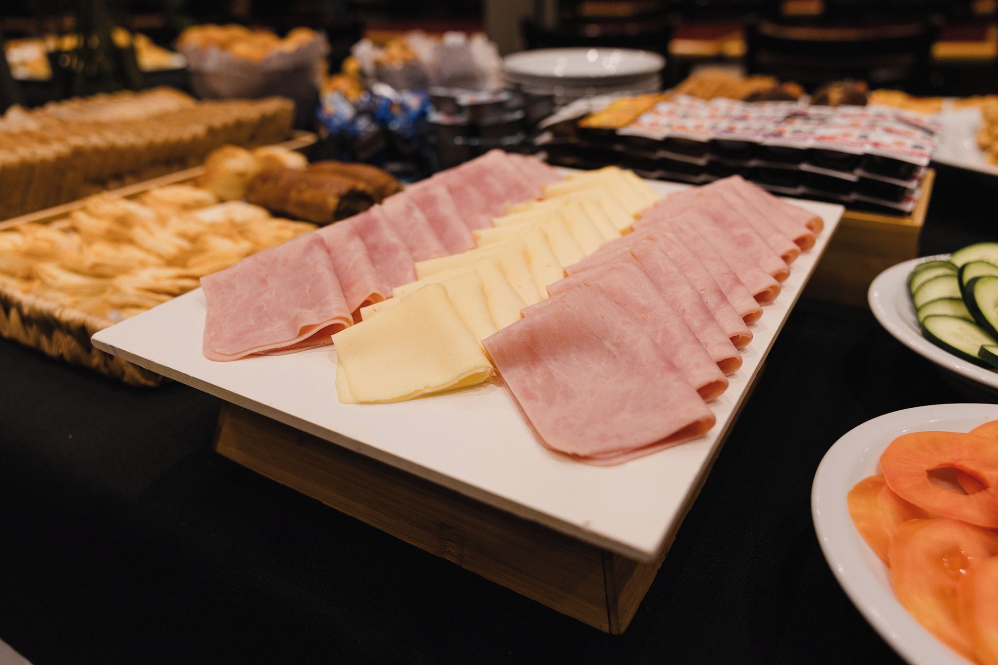 A buffet with various meats and cheeses.