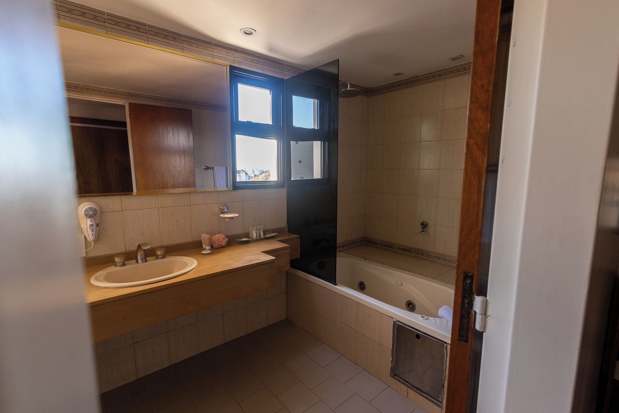 Un baño con lavamanos doble, bañera y ventana.