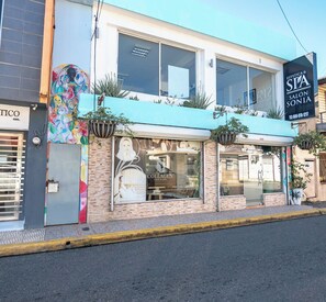 Un bâtiment abritant un salon de spa, le café-bar Collagen, et une fresque murale aux couleurs vives.