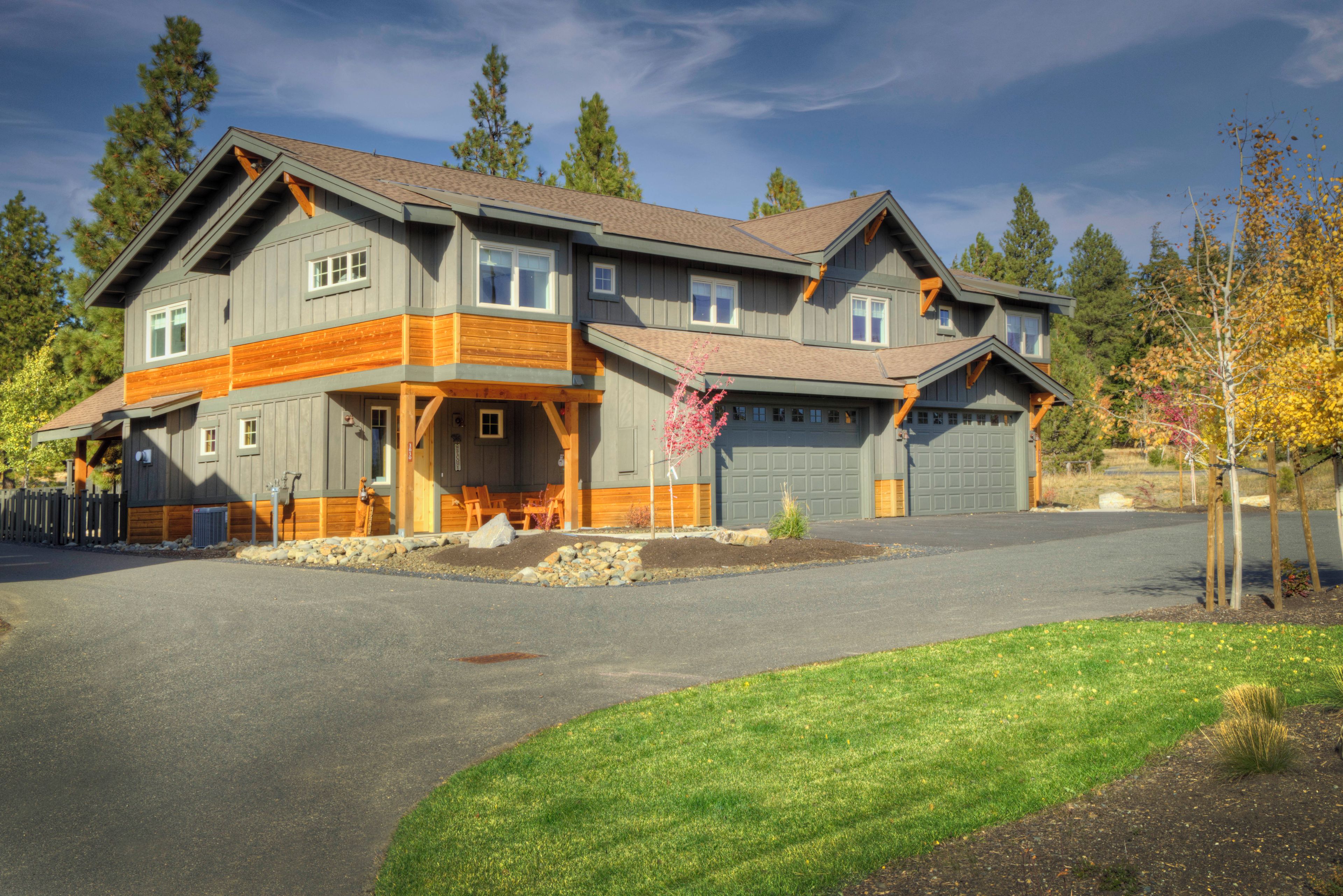 A two-story house with a garage, a covered porch, and a driveway.