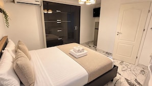 Een hotelkamer met een bed, een kledingkast, een badkamer en een deur.