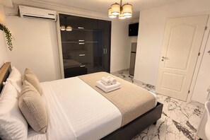 A hotel room with a bed, a wardrobe, a bathroom, and a door. - Modern Studio | Central Bucharest (Bucharest)