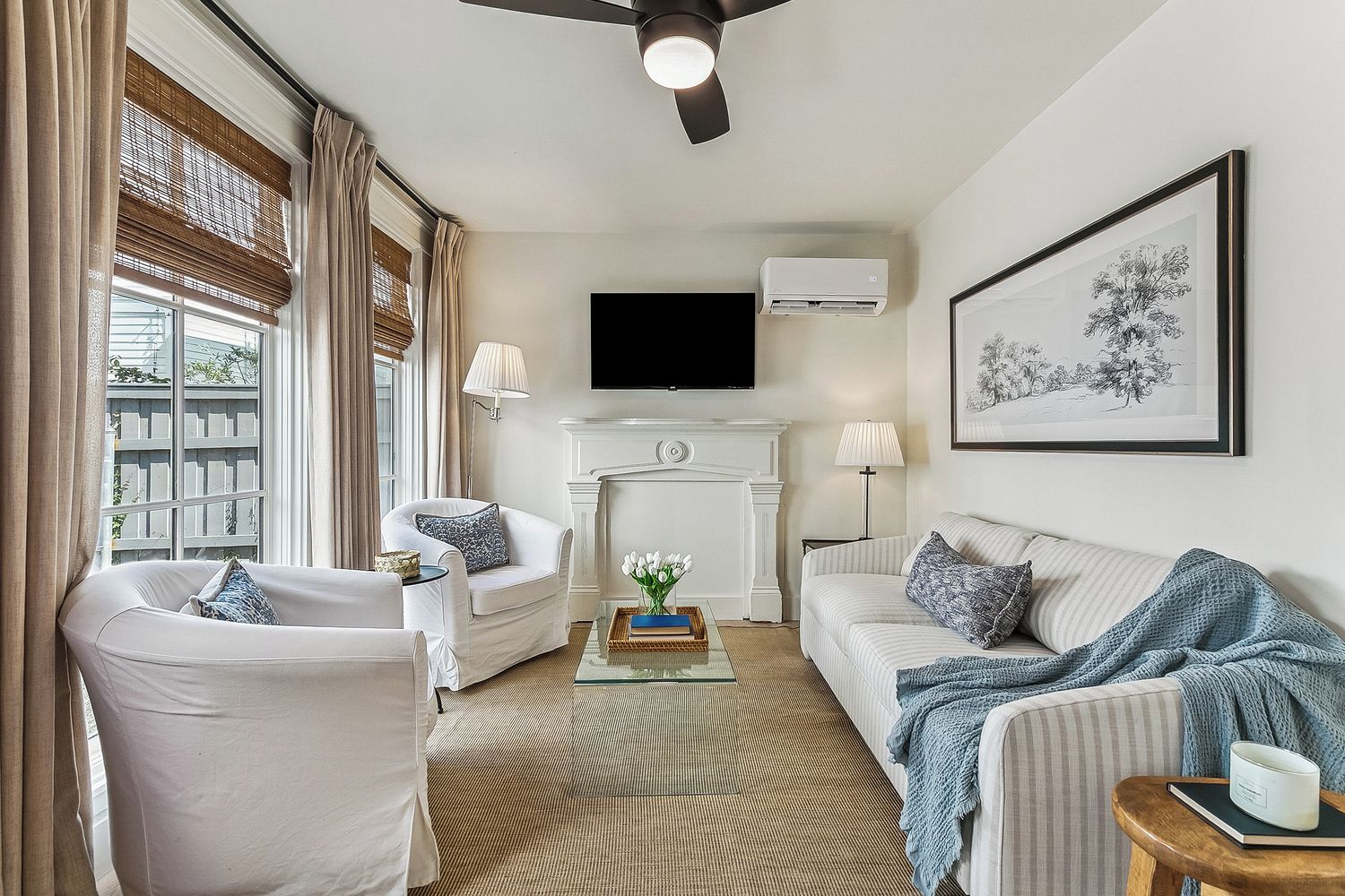 A living room with a fireplace, a flat-screen TV, and a large framed artwork on the wall.