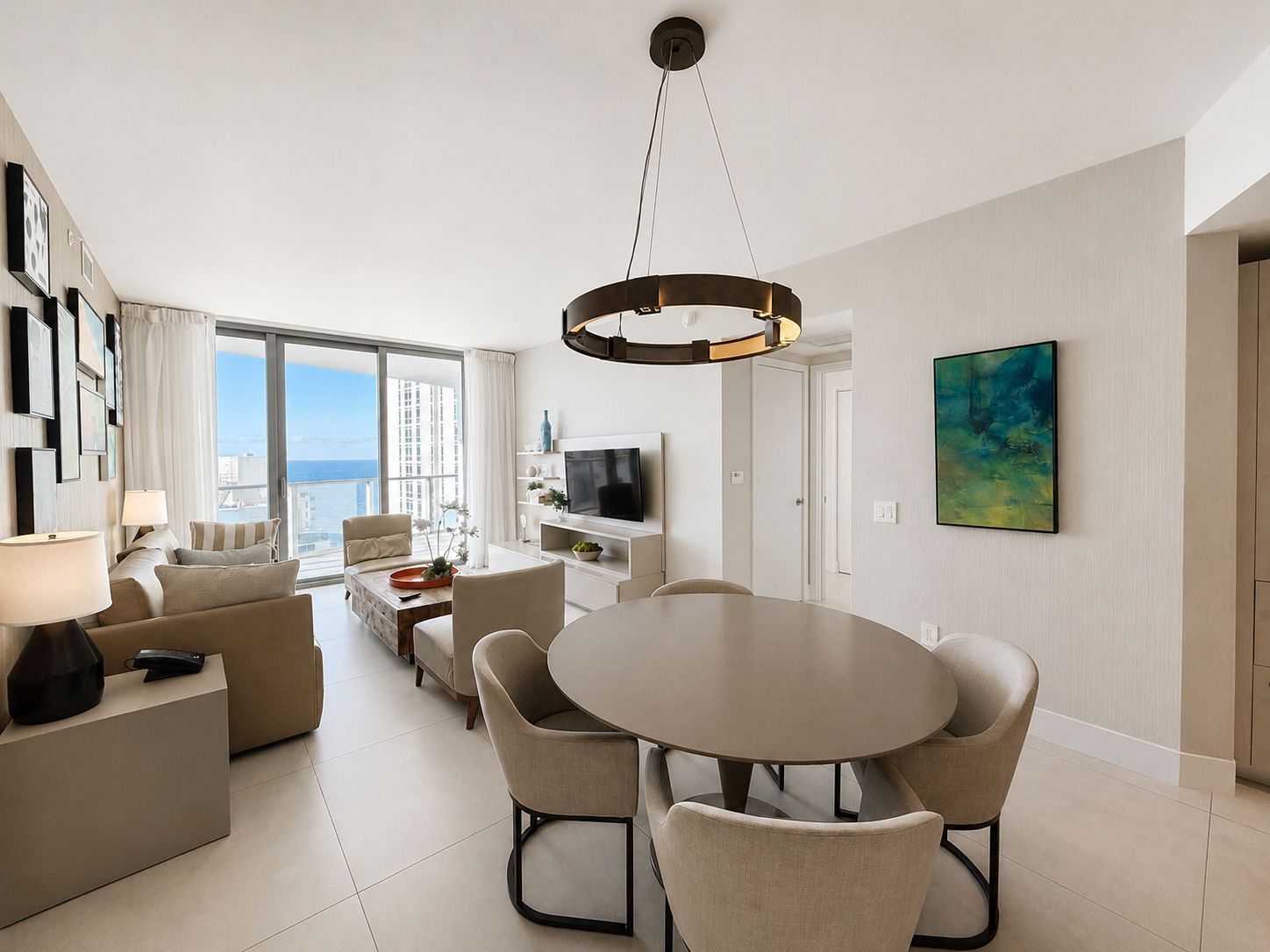 Ein modernes Wohnzimmer mit Essbereich, großen Fenstern und Meerblick.
