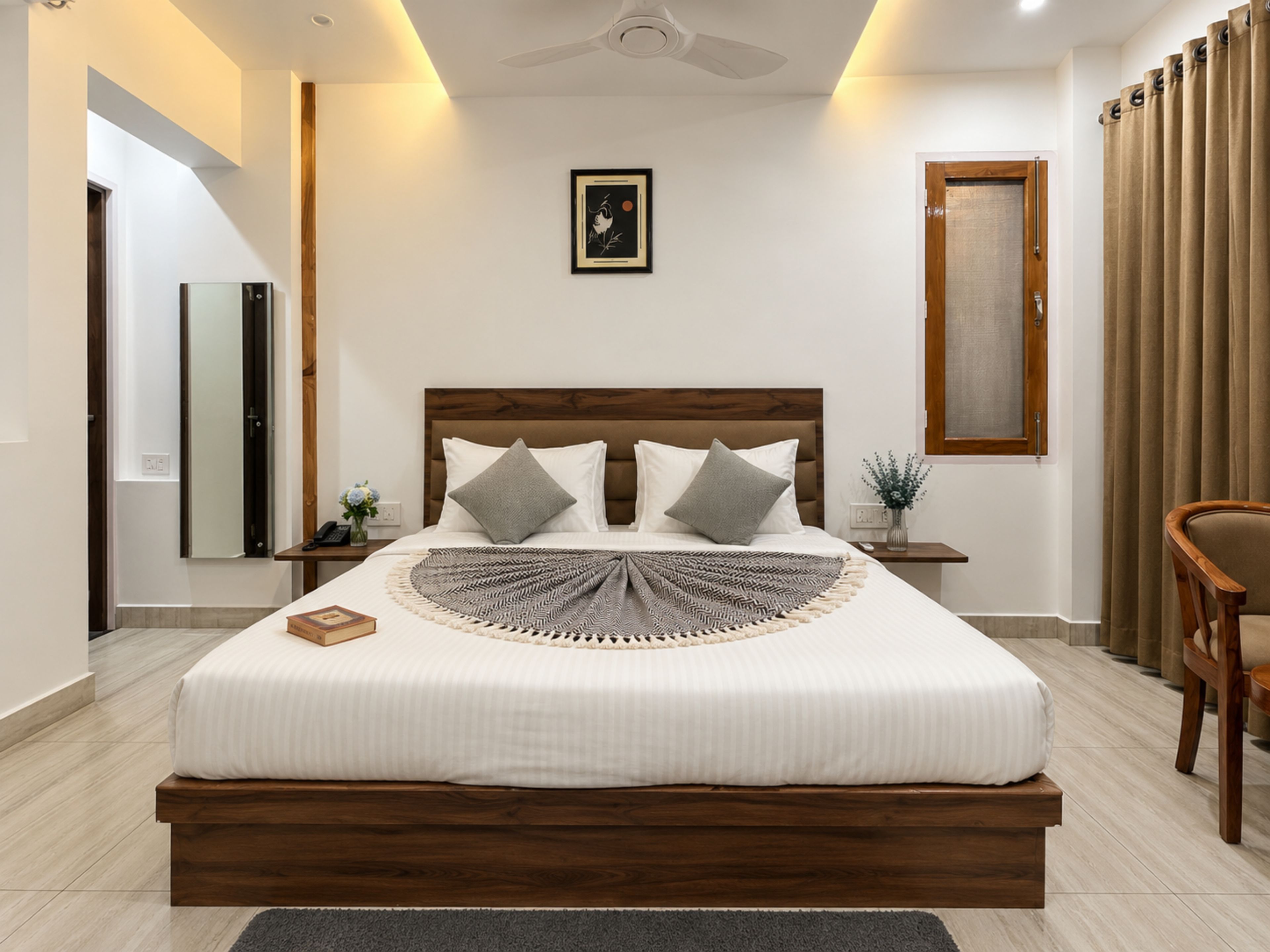 A modern bedroom with a large bed, wooden headboard, and a ceiling fan.