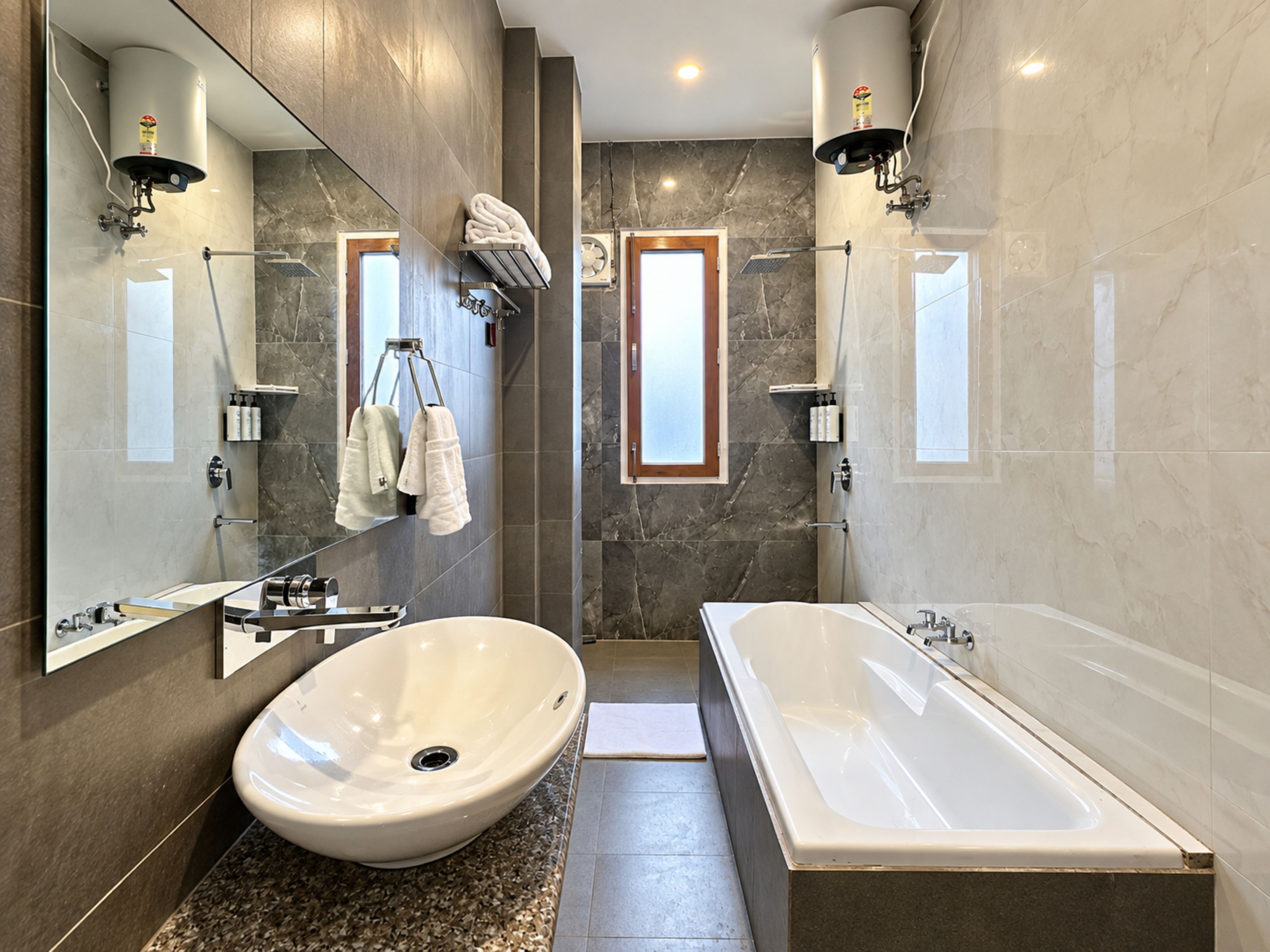 A modern bathroom with a large oval sink, a freestanding bathtub, and a mirror with towel racks.
