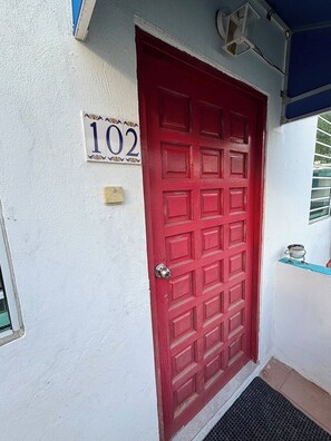 A red door with a mailbox and a number sign above it. - 15 Minutes Airport, 10 Minutes Old San Juan, Private Patio and Share Pool (San Juan)
