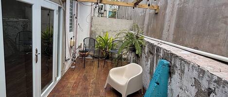 A wooden deck with a built-in seating area, a concrete wall, and a view of the city.