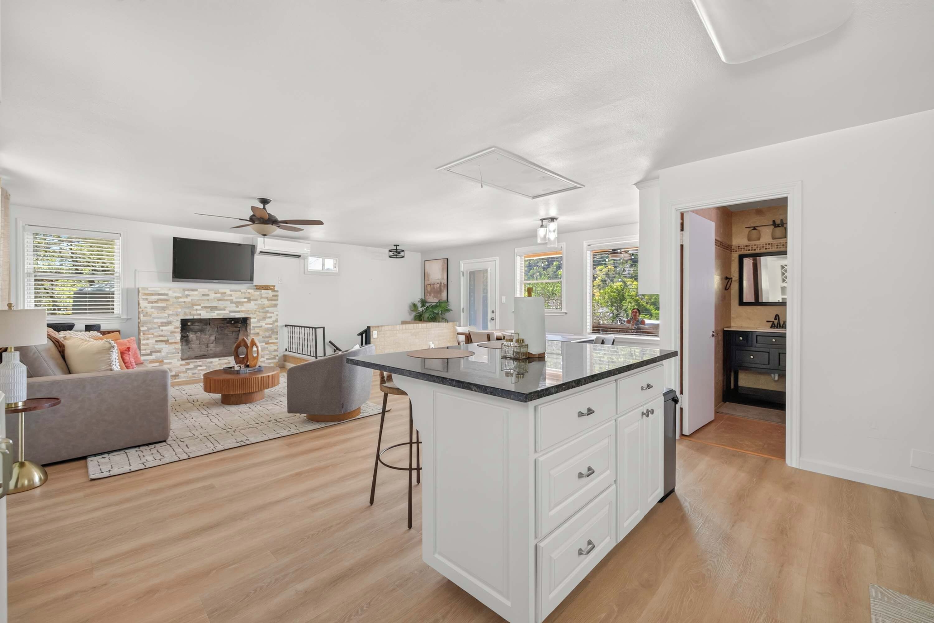 Amplia sala de estar con chimenea, cocina con una isla grande y comedor.