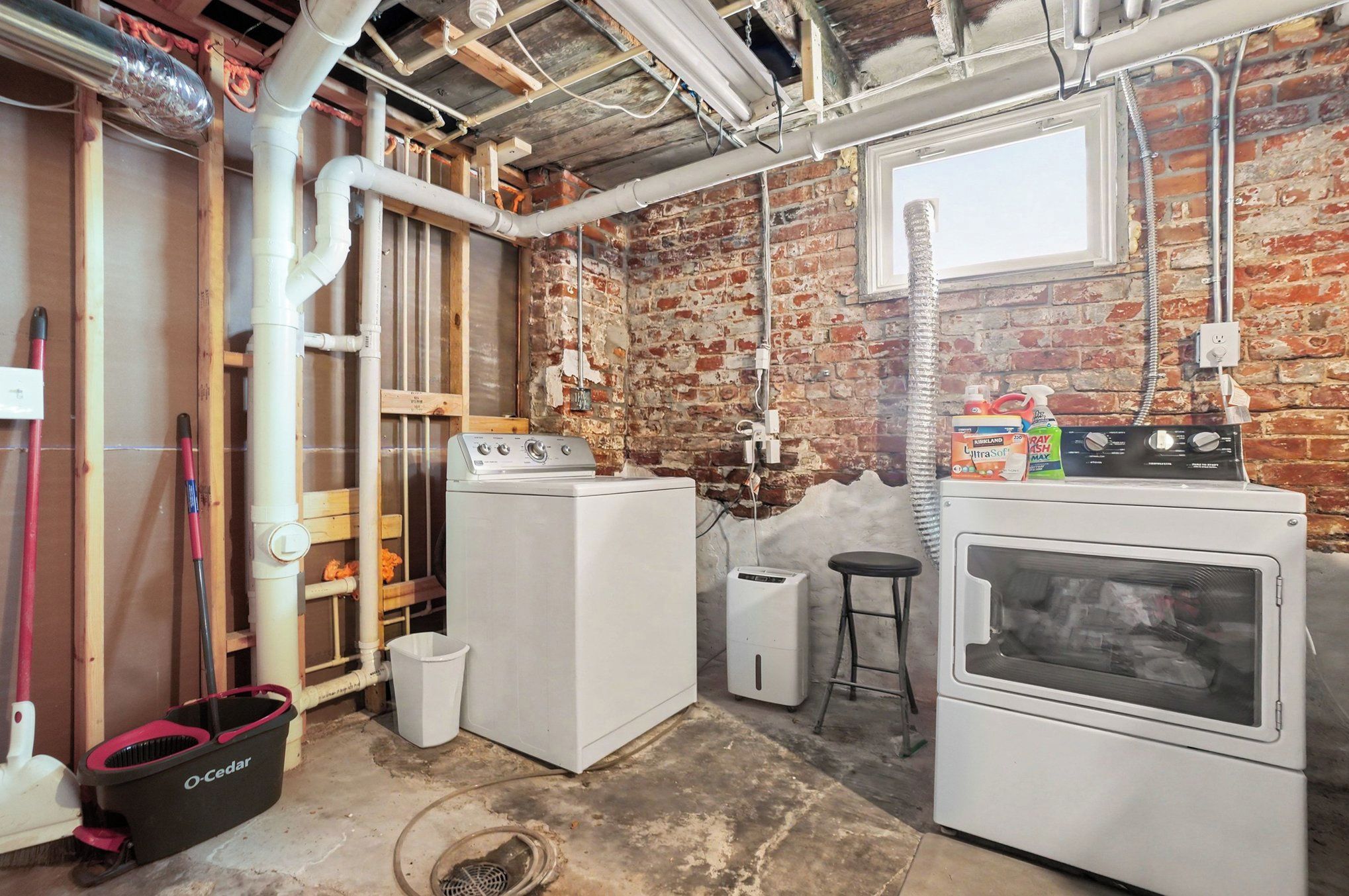 A laundry room with a washing machine, dryer, and a utility sink.