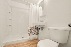 Un baño con ducha, inodoro y lavamanos.