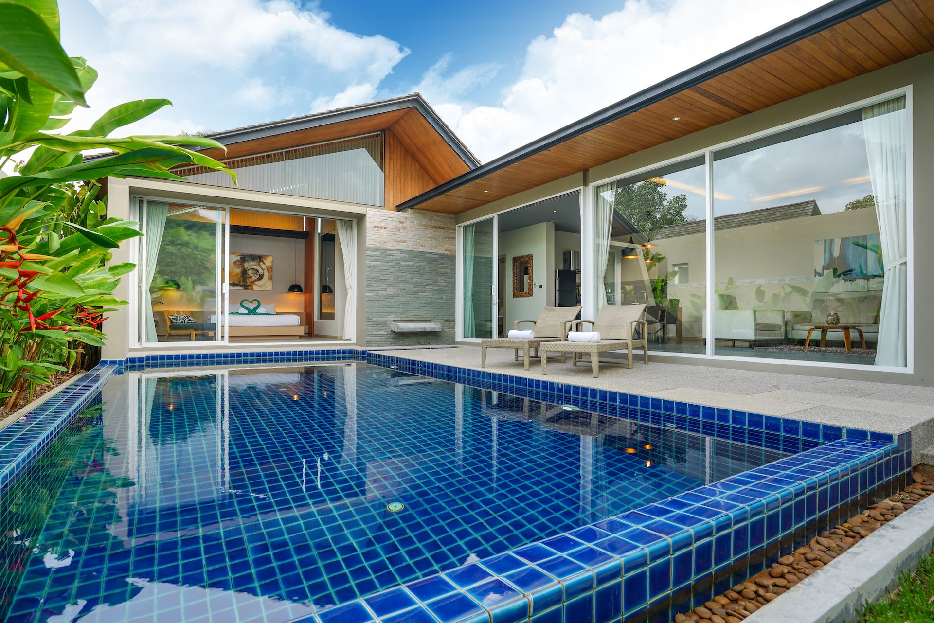 A modern house with a swimming pool, large windows, and a patio area.