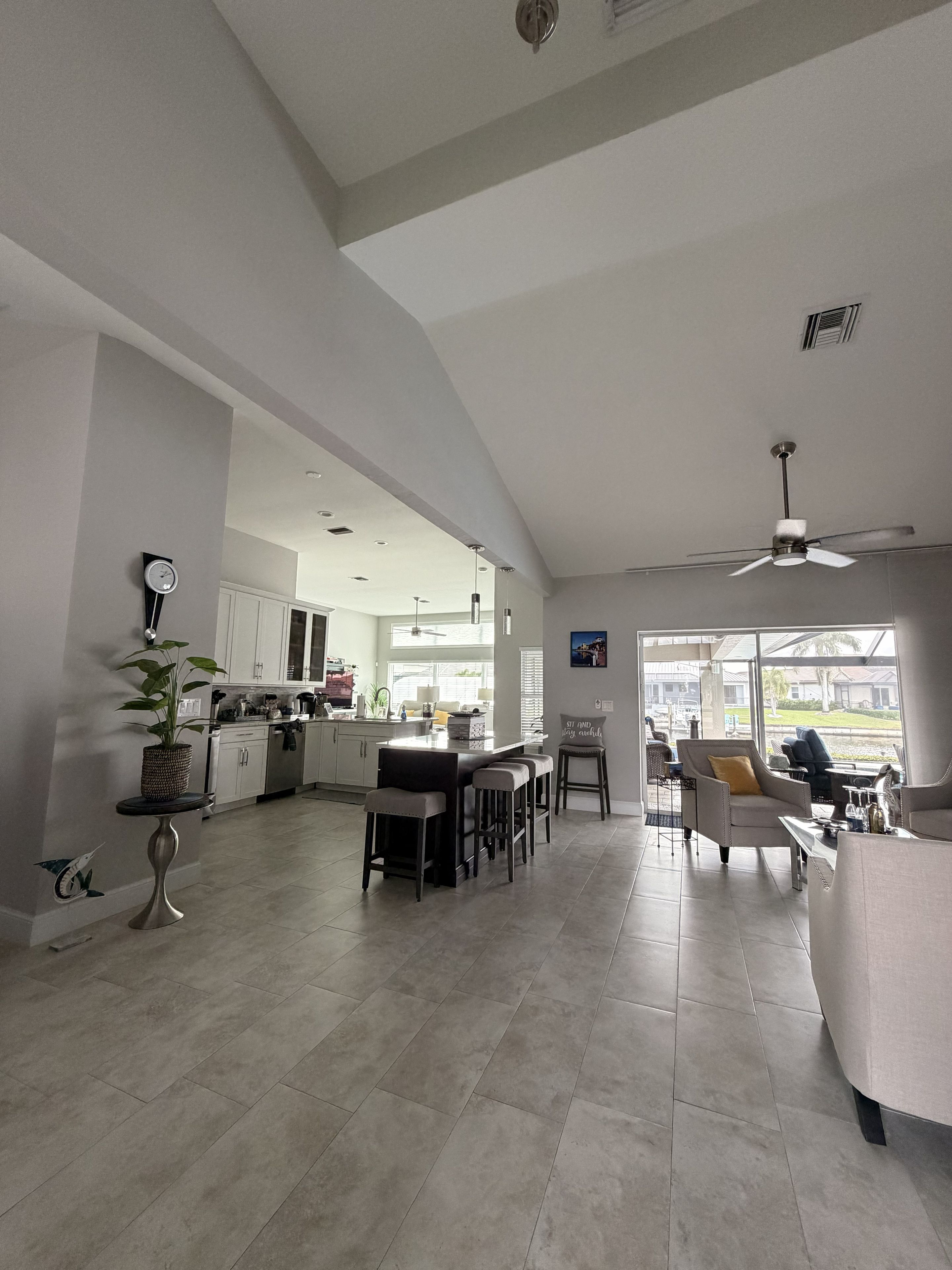 Amplia sala de estar con cocina, comedor y una zona de descanso con ventilador de techo.