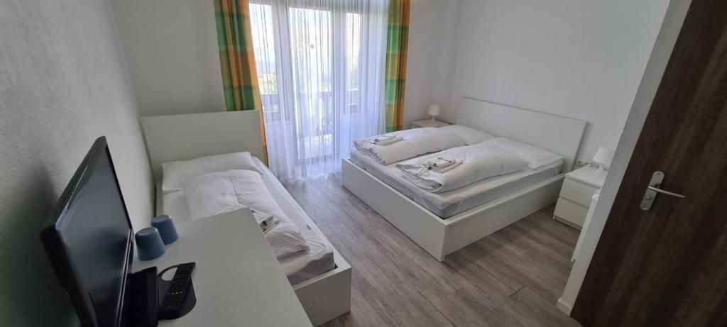 A bedroom with a bed, a desk, and a chair.