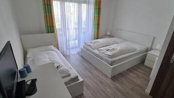 A bedroom with a bed, a desk, and a chair.