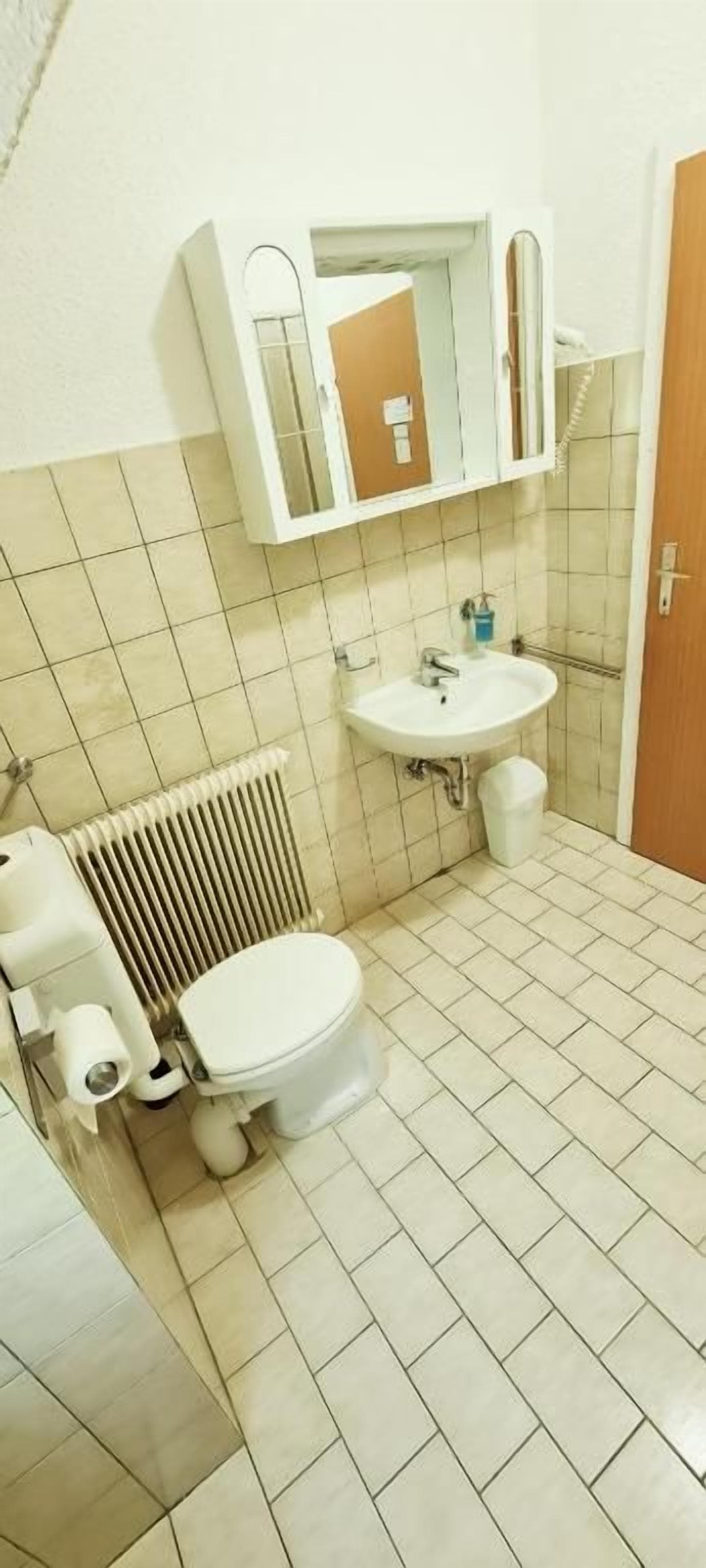 Ein Badezimmer mit Toilette, Waschbecken und Spiegel.