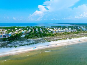 An aerial view of a coastal residential area with houses, a beach, and a clear sky. - Boardwalk Bungalow (Port St. Joe)