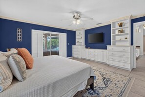 A bedroom with a bed, white dresser, TV, and a ceiling fan. - Imperial Retreat | Family Friendly Pool Home (Bonita Springs)