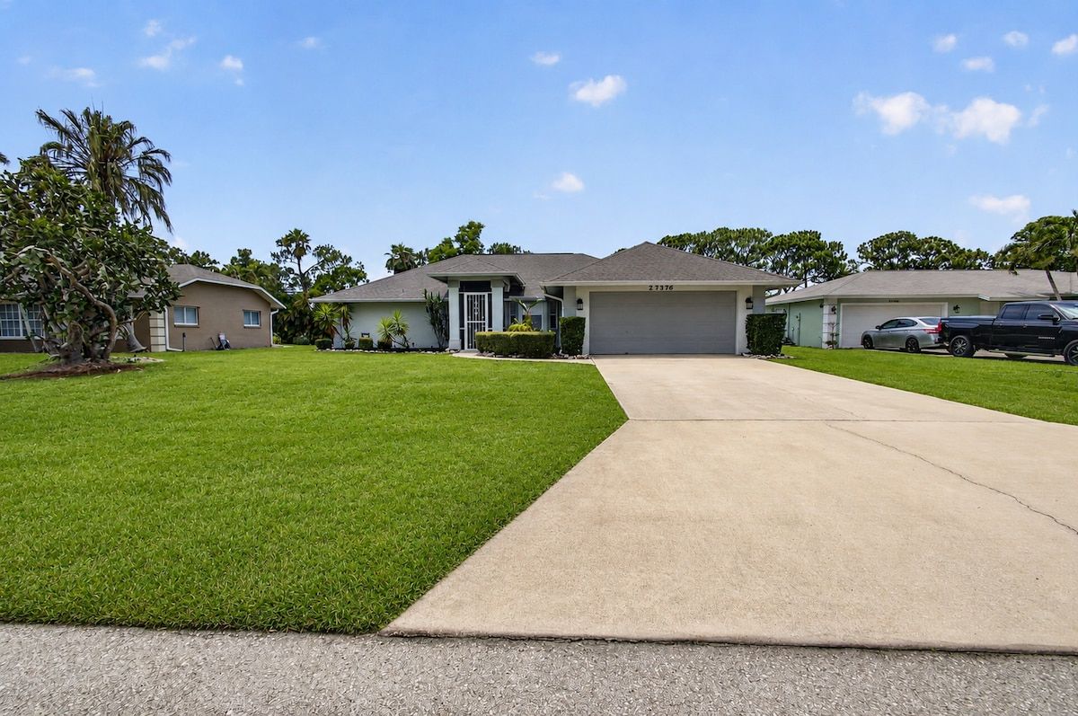 A residential area with houses, a driveway, and a clear sky.