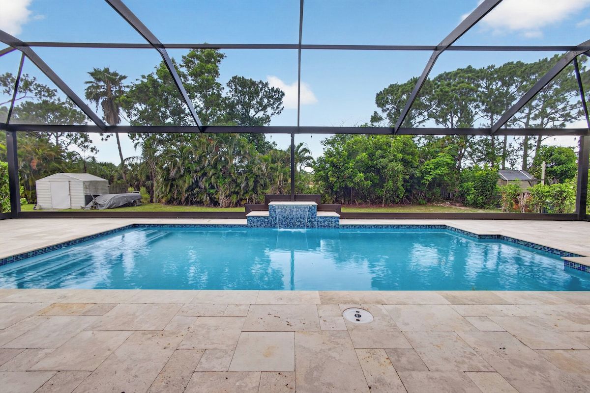 Una piscina con borde de azulejos, rodeada por una zona techada con estructura metálica.
