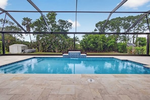 A swimming pool with a tiled edge, surrounded by a covered area with a metal frame. - Imperial Retreat | Family Friendly Pool Home (Bonita Springs)
