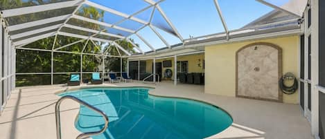Piscina coberta com teto de vidro, rodeada por espreguiçadeiras e um solário.