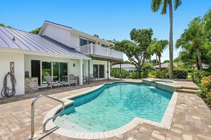 A modern house with a swimming pool, outdoor seating, and a covered patio area. - The Palms at McGregor | Luxury 4BR Pool Home (Fort Myers)