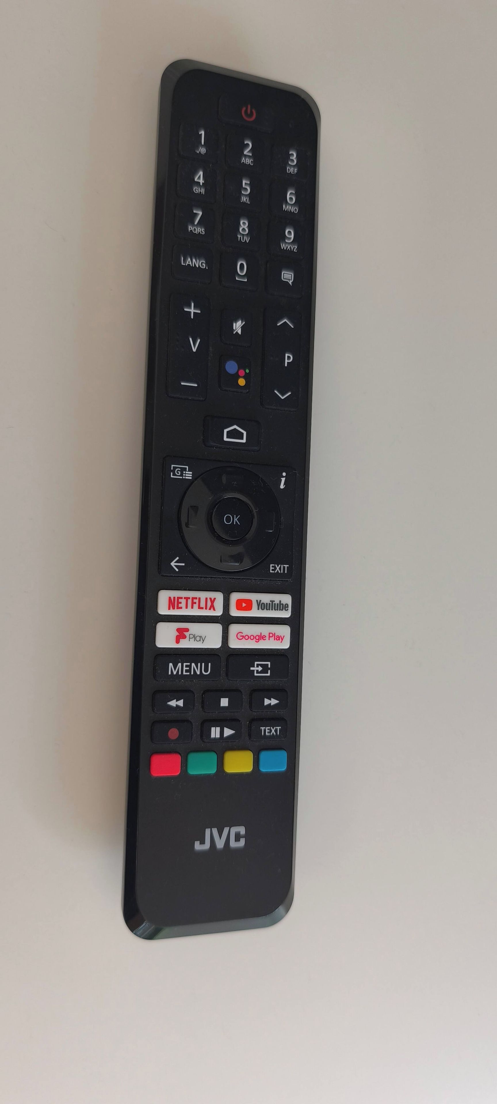 Un control remoto JVC negro con teclado numérico, botones direccionales y funciones para Netflix, YouTube, reproducción, Google Play y navegación por el menú.