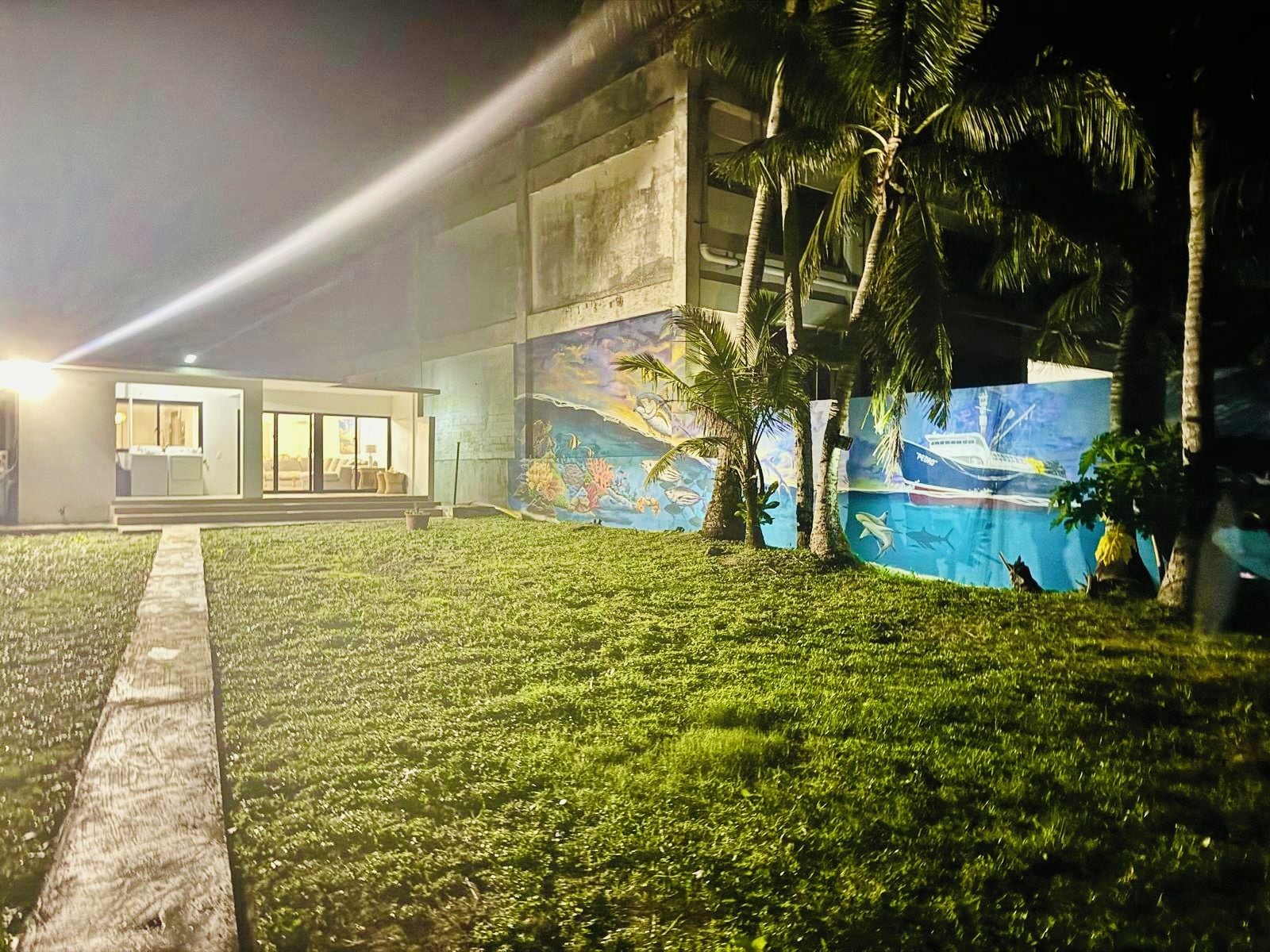Un bâtiment moderne doté d’une pelouse bien entretenue et d’une fresque représentant la vie marine.