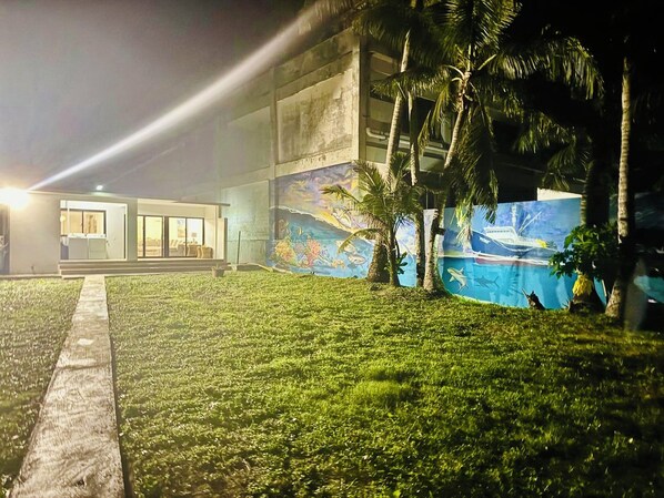A modern building with a well-maintained lawn and a mural depicting marine life.