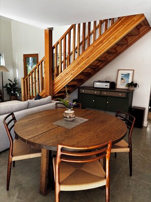 Ein Essbereich mit einem Holztisch, Stühlen und einer Treppe.