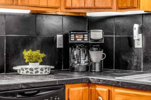 A kitchen with a coffee maker, a cup, and a potted plant on the counter. - Captain Morgan`s Fort · New Listing! Steps to the Beach & Gulf Views (Gulf Shores)