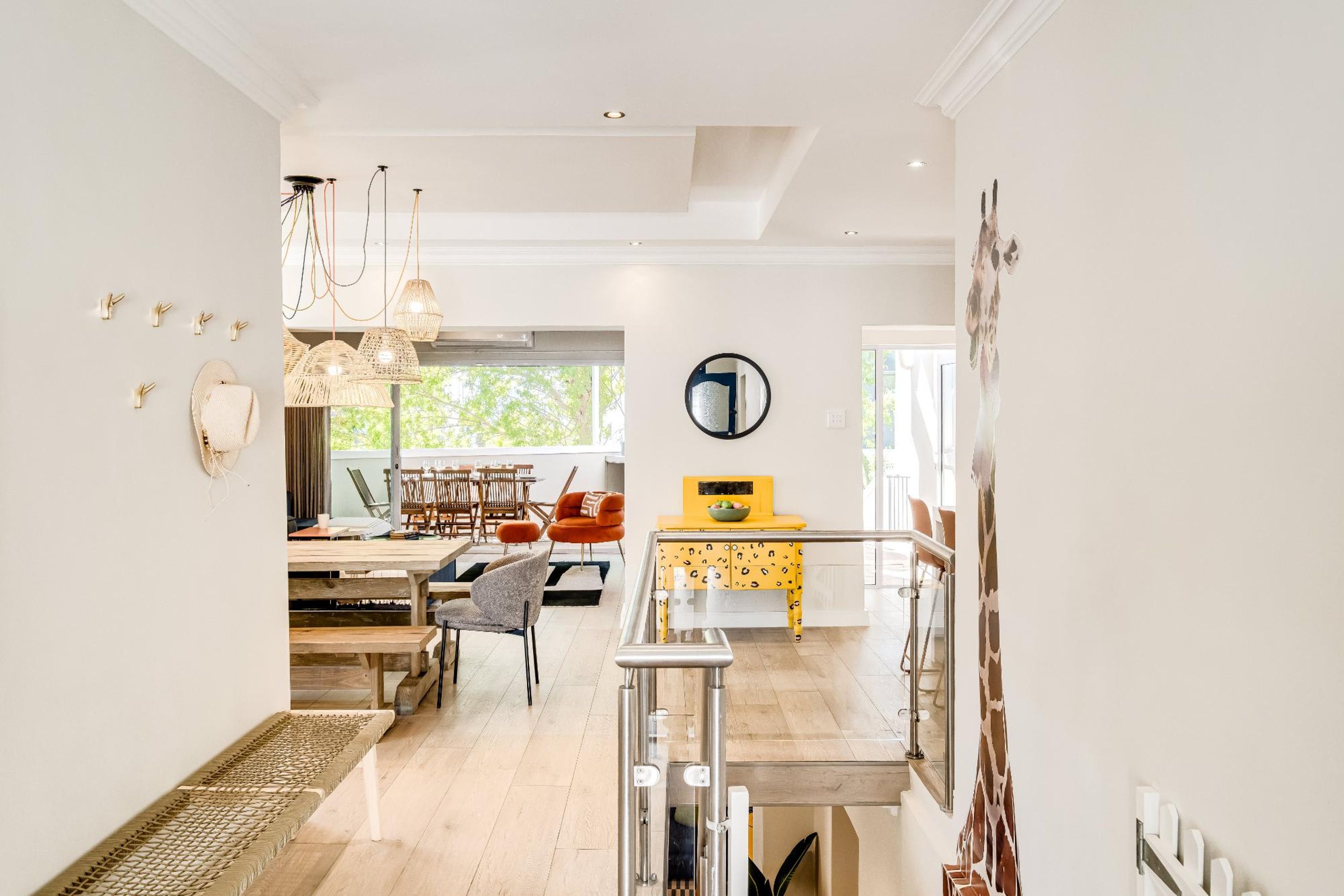 A spacious living area with a dining table, chairs, and a yellow cabinet.