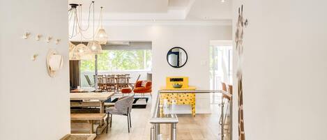 A spacious living area with a dining table, chairs, and a yellow cabinet.