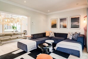 Ein modernes Wohnzimmer mit einer Eckcouch, einem Couchtisch und einem Essbereich mit einer Bank.