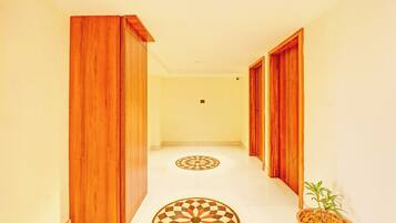 A hallway with wooden doors and a checkered floor pattern.