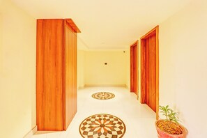 Un pasillo con puertas de madera y un suelo a cuadros.