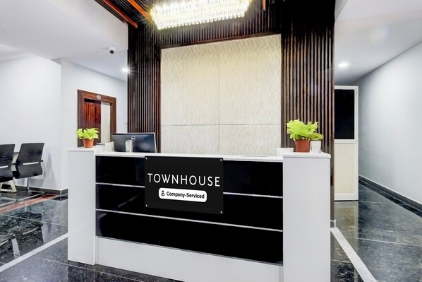 A reception desk with a sign reading 'TOWNHOUSE Company-Serviced.'